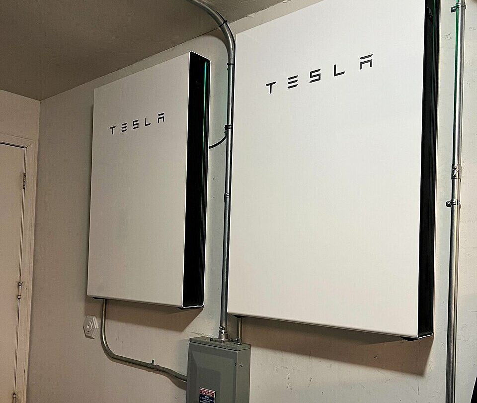 Dwa magazyny Tesla Powerwall 3 zamontowane wewnątrz budynku mieszkalnego, fotografia z 2024 roku. Ilustracja technologii, nie rekomendacja marki ani potwierdzenie kwalifikacji do polskiej dotacji.