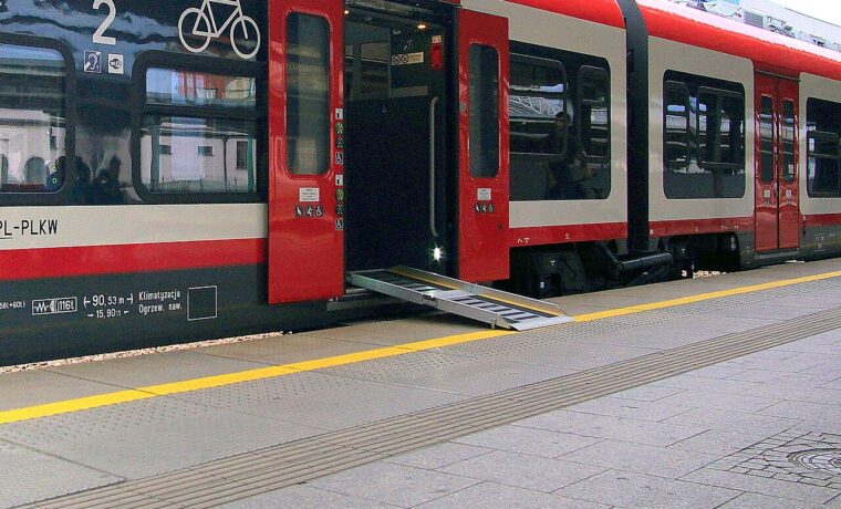 Rozłożona pochylnia umożliwiająca wjazd wózka do pociągu; fotografia ilustracyjna dostępności transportu