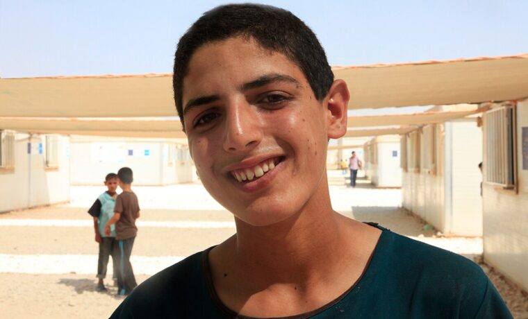 Młody edukator na terenie szkoły w obozie Zaatari w Jordanii, fotografia z 2013 roku; nie przedstawia wizyty UNICEF z 2026 ani osób opisanych w danych o ubóstwie