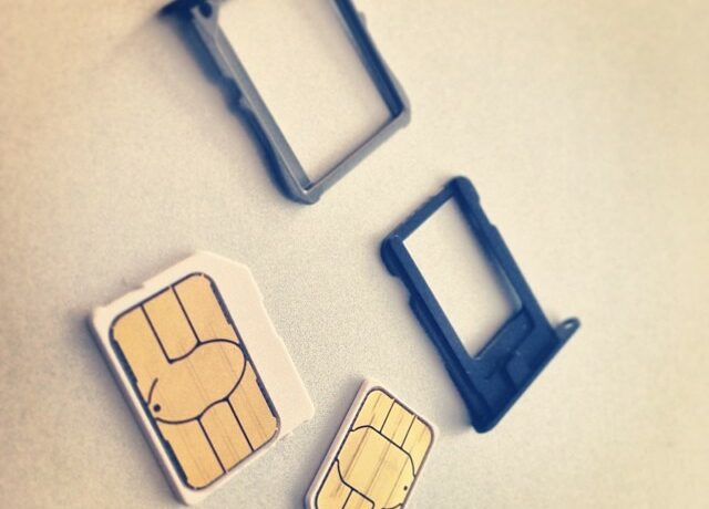 Karty micro-SIM i nano-SIM wraz z tackami telefonów; ilustracja usług komórkowych