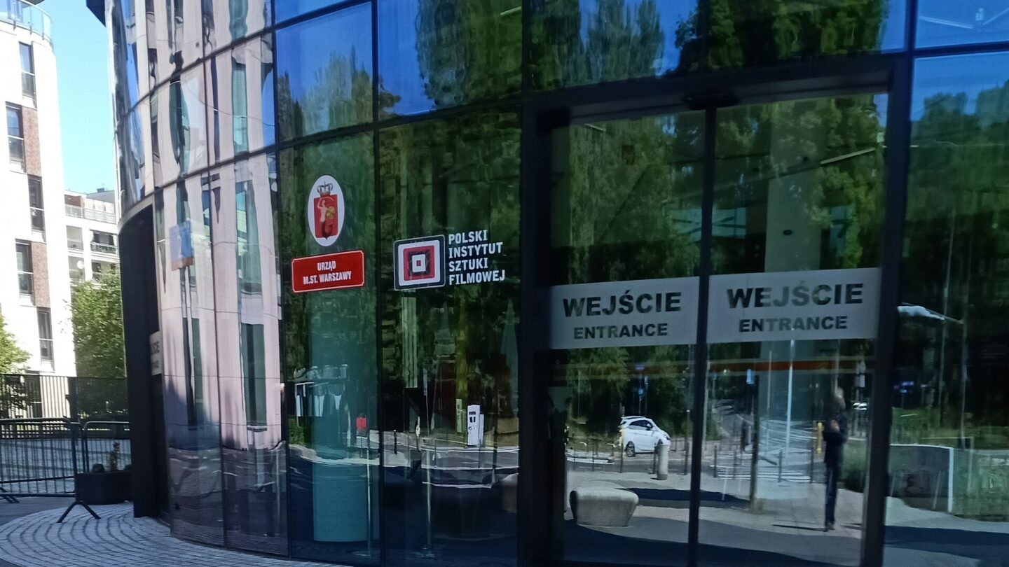Wejście do budynku Powiśle Park z oznaczeniem Polskiego Instytutu Sztuki Filmowej. Zdjęcie z czerwca 2024 roku.